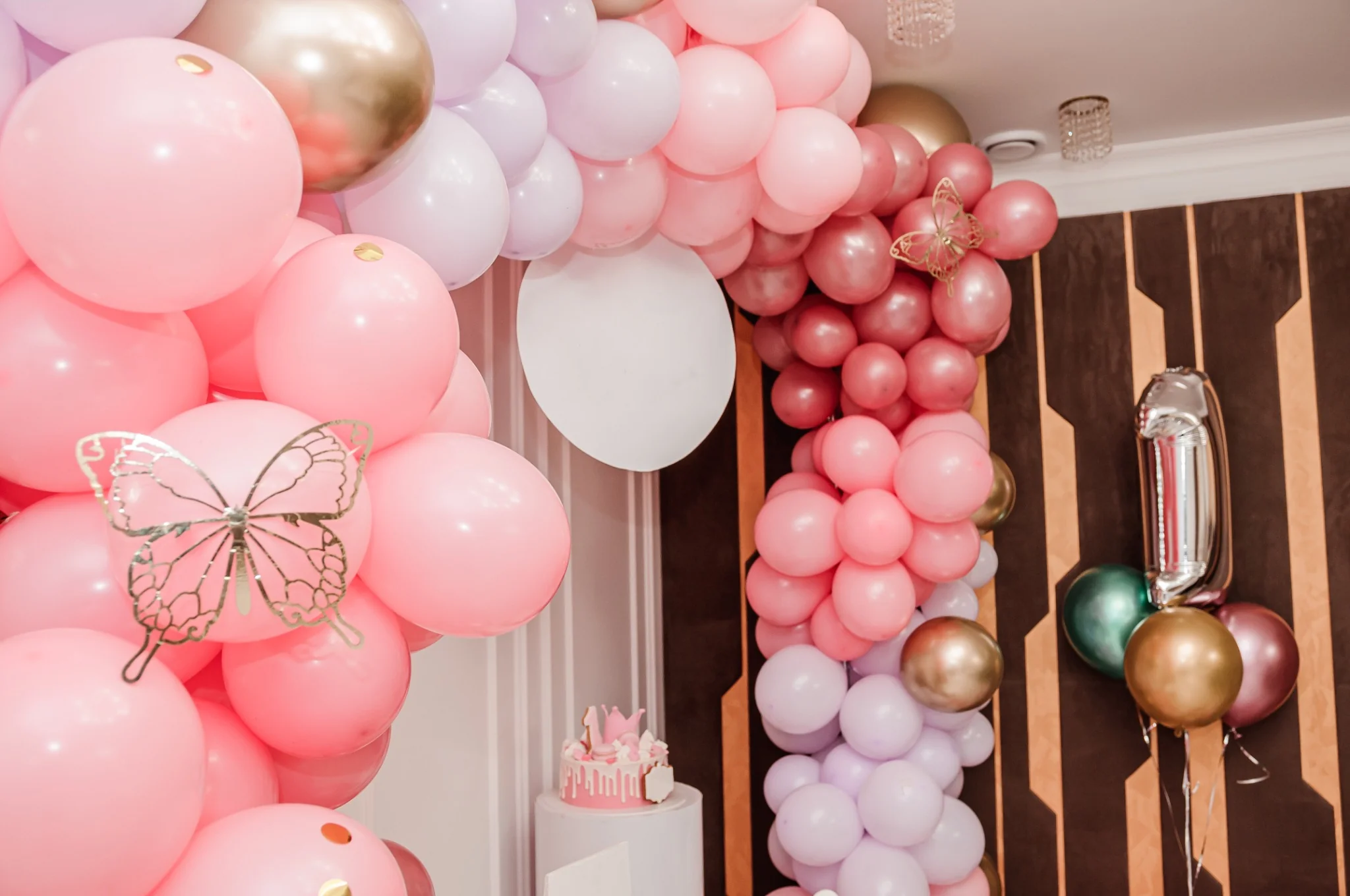 Üppige Ballongirlande in Rosa, Weiß und Gold mit Schmetterlingen